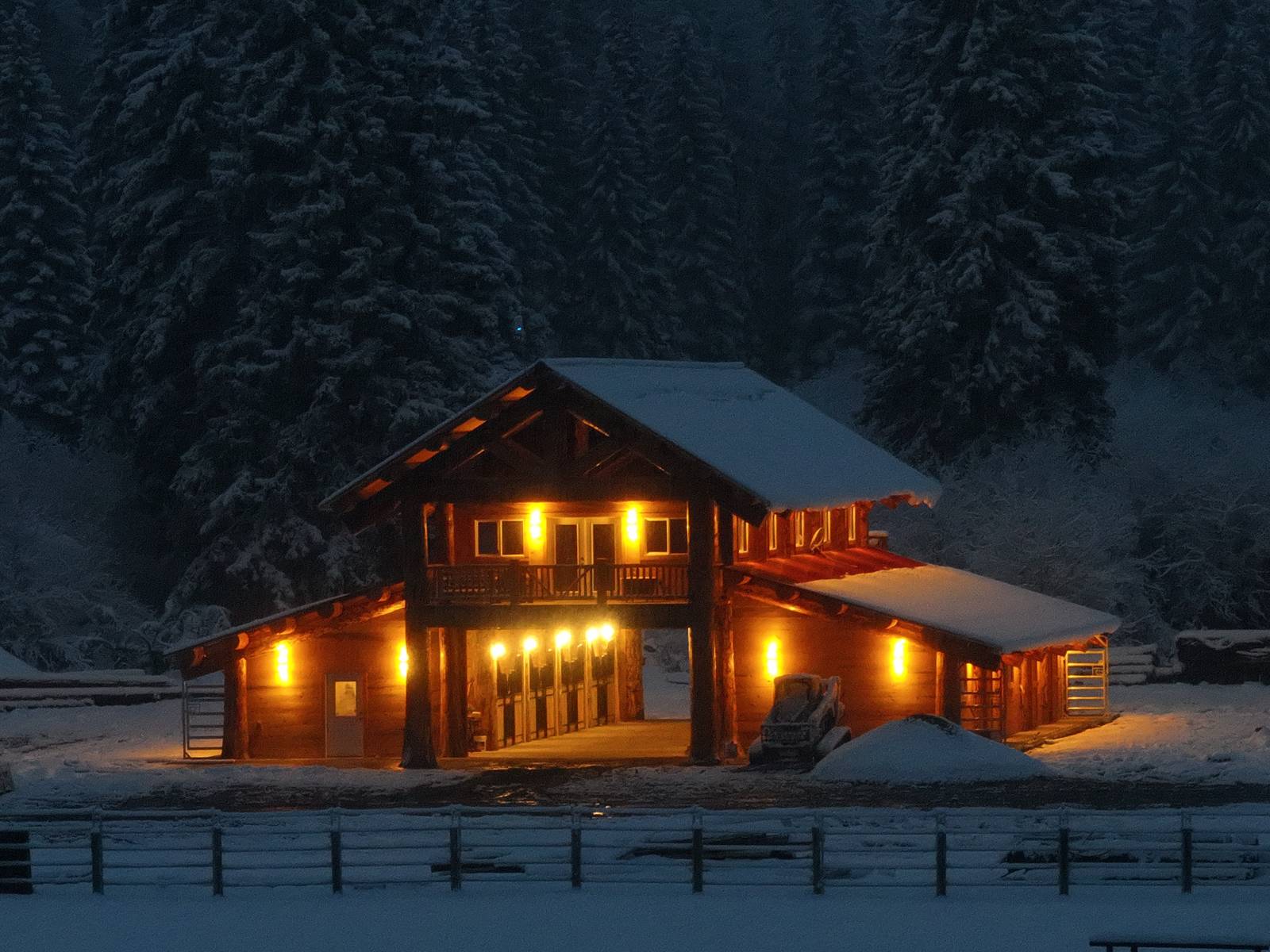 Log barn at dusk with lights on