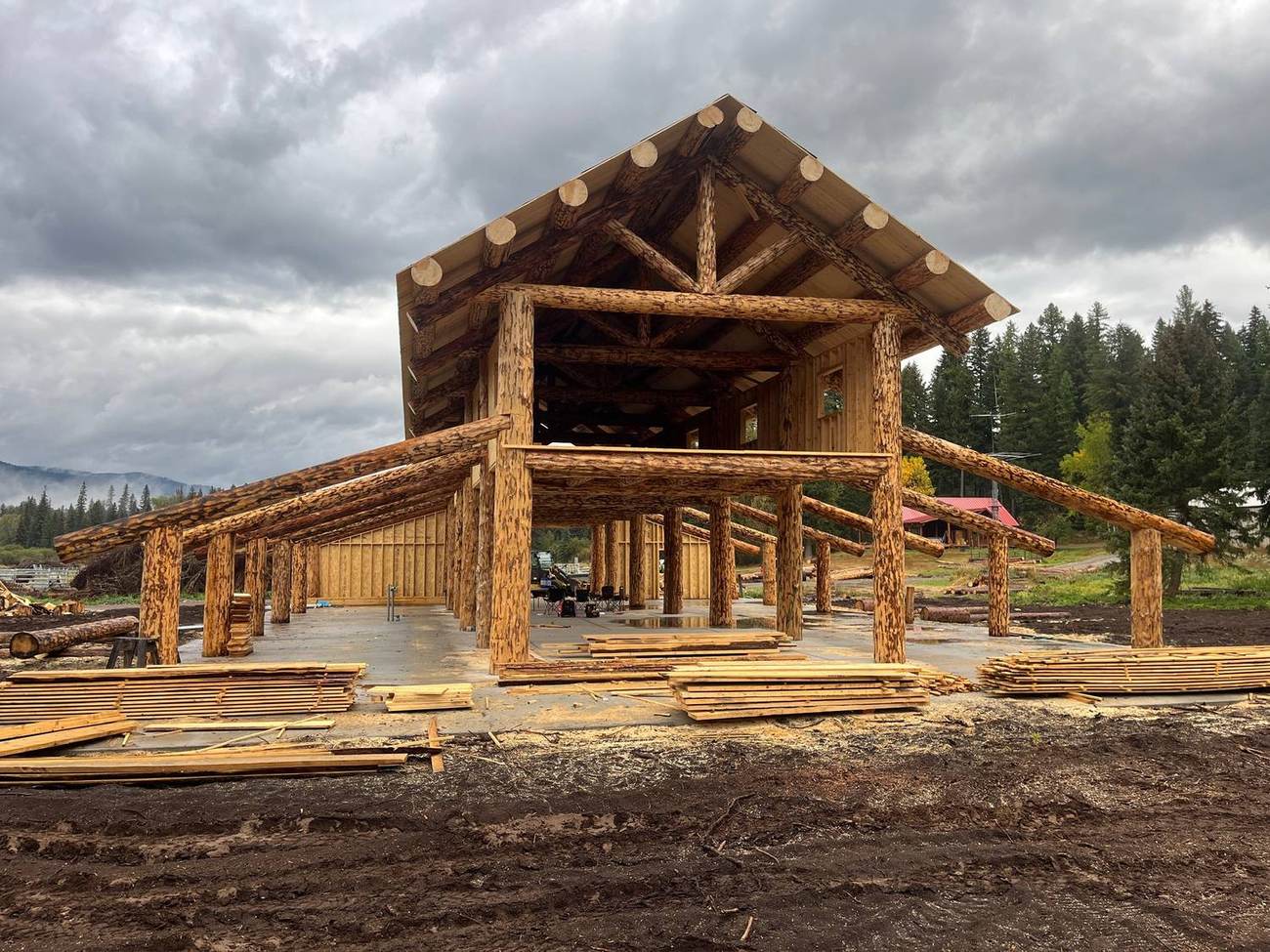 The barn frame from the ground with lumber stacked