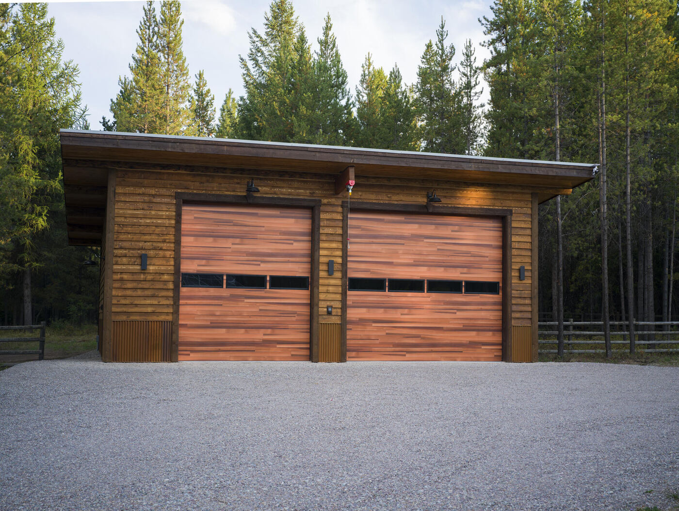 The garage straight on, two cedar overhead doors under a single-pitch roof