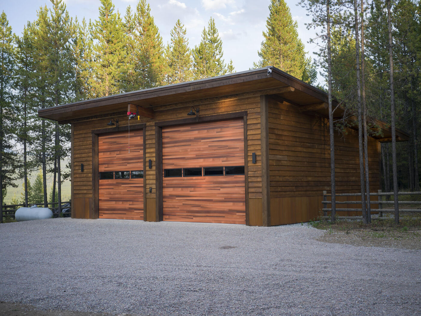 The garage from the far side with the forest and rail fence behind