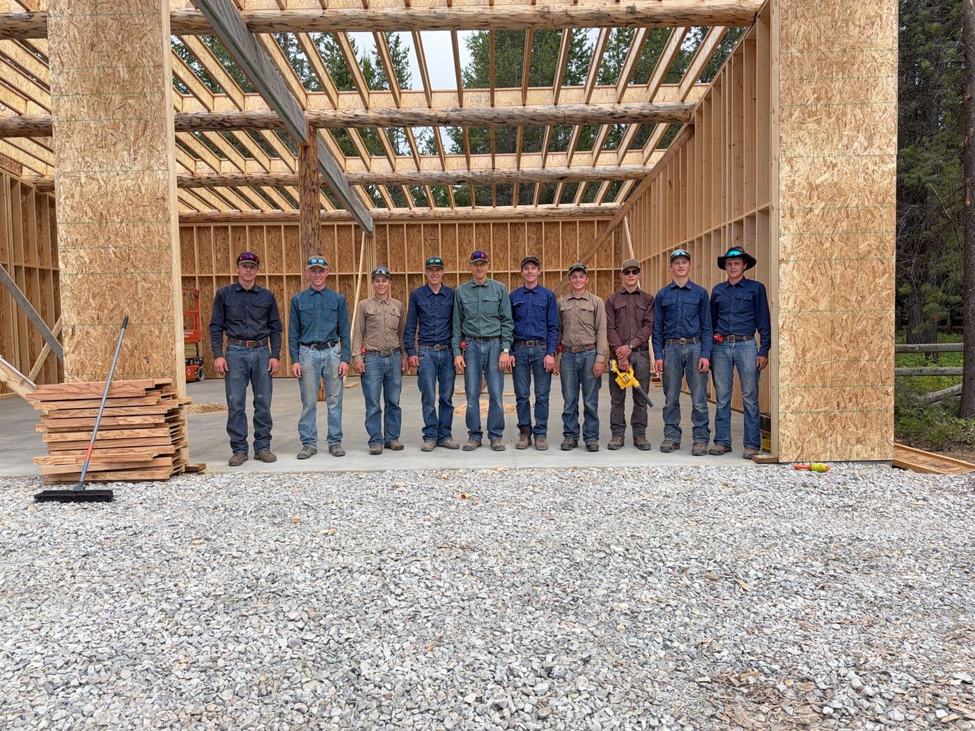 The crew lined up inside the framed garage beneath the beam they set