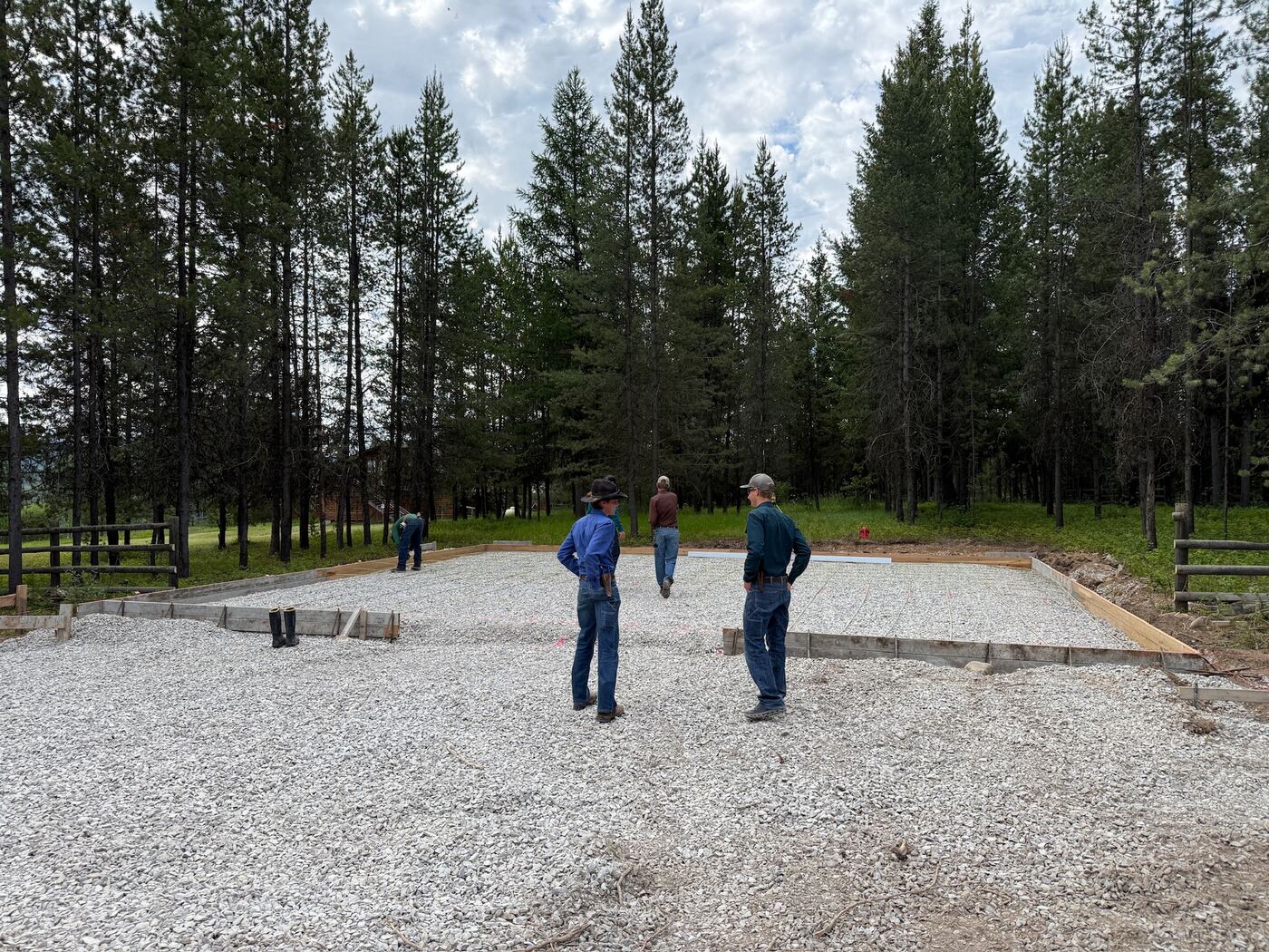 Crew on the compacted gravel pad with the edge forms set