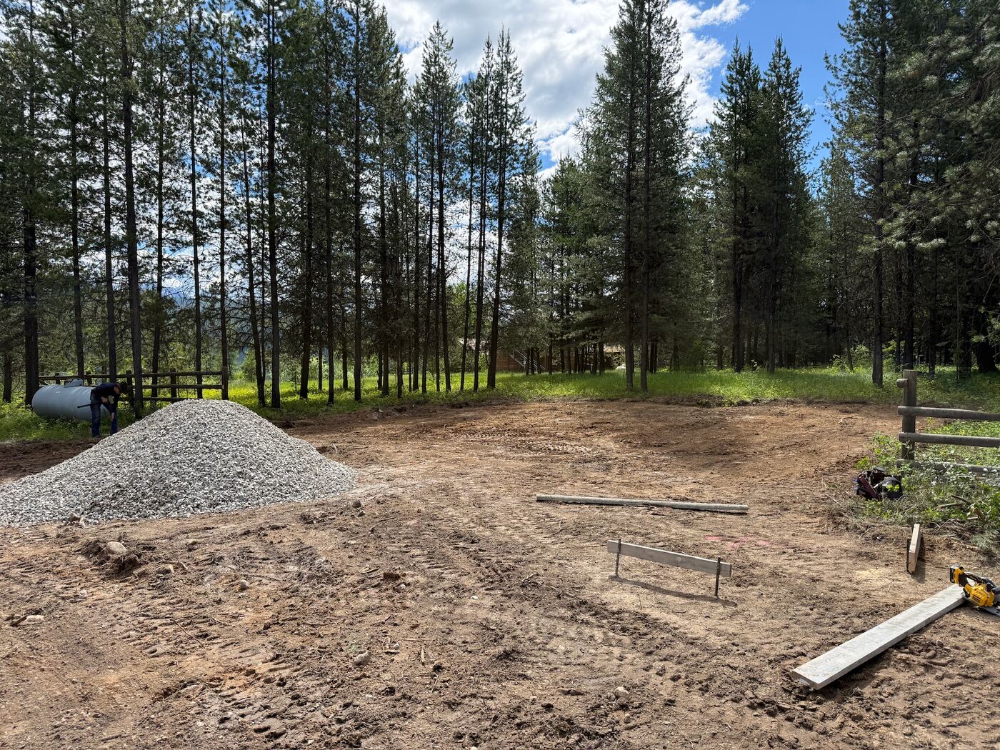 Crushed gravel stockpiled on the graded building pad with string lines run