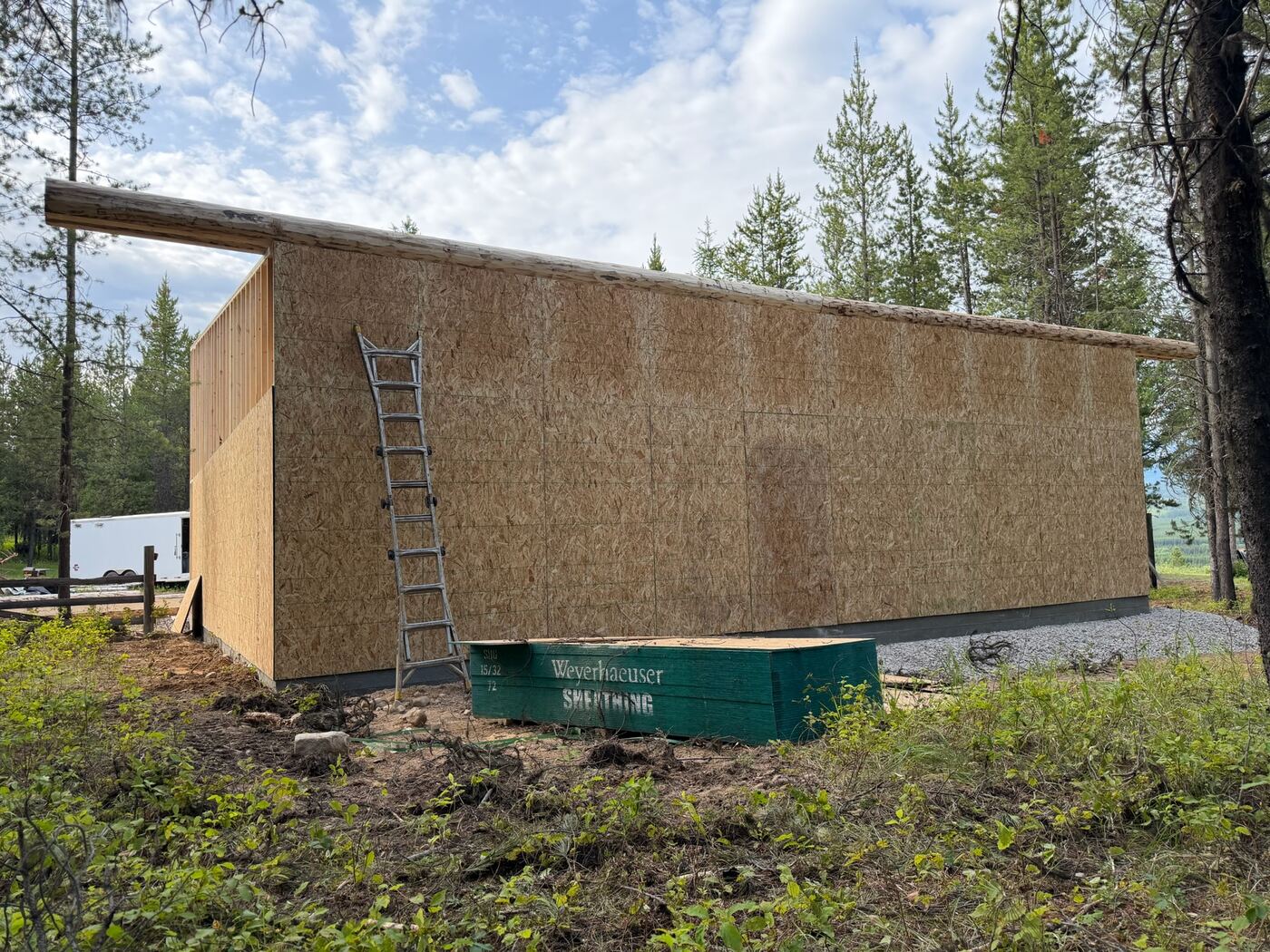 The long sheathed wall of the garage under the single-pitch roof line