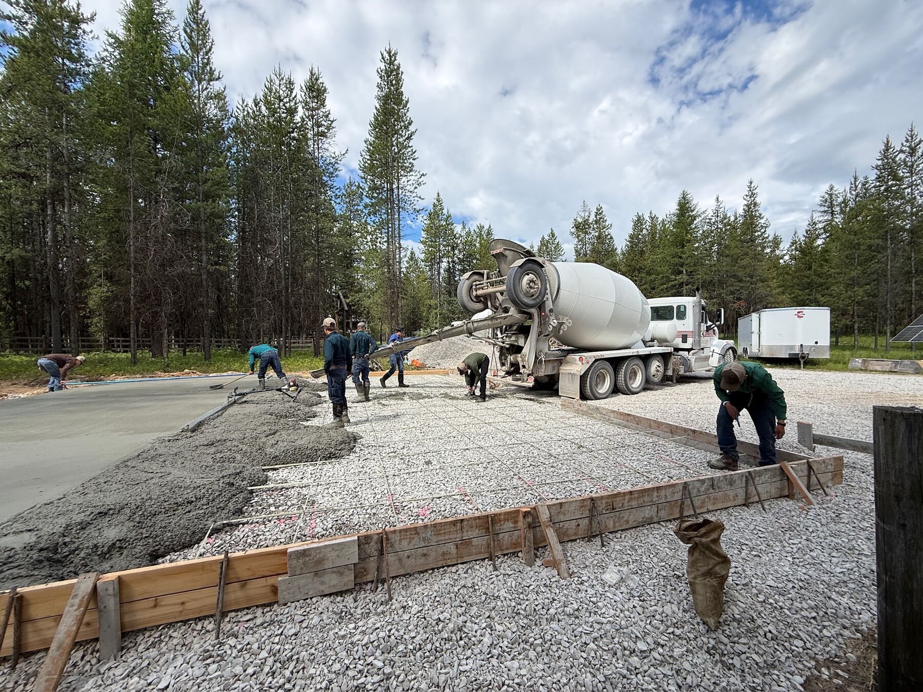 Crew placing concrete from a mixer truck into the formed slab