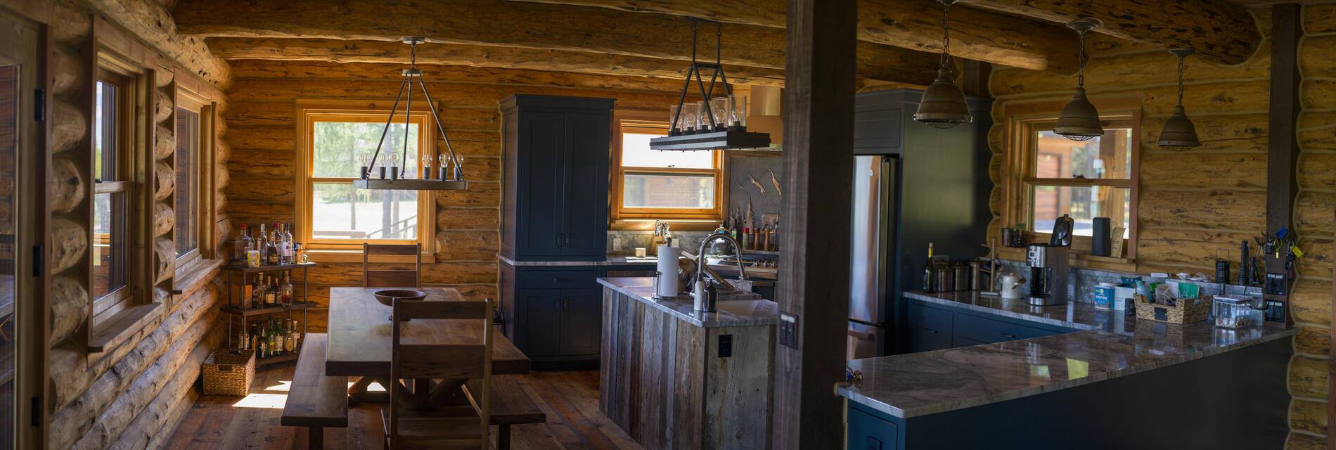 Kitchen and dining under log walls and beams