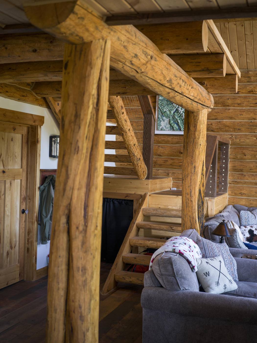 Log stair and structural post rising through the living space
